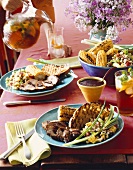 Pork with grilled corn on the cob, bread and bean salad