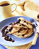 Stack of Blueberry Pancakes with Blueberry Sauce on a Blue Plate; Cup of Coffee