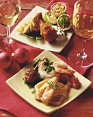 Assorted Christmas Appetizers on Square Plates; Glasses of White Wine and Christmas Decorations