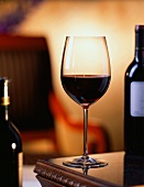Glas Rotwein auf Tisch im Wohnzimmer