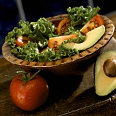 Salad with Tomato and Avocado in a Bowl, Tomato and Half an Avocado