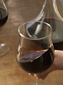 Hand schwenkt ein Glas Rotwein