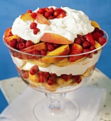 Trifle with peaches, berries, cream and sponge fingers