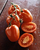 Plum tomatoes, one halved