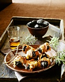 Bacon-wrapped prunes with rosemary & glass of sherry on tray