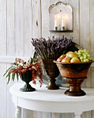 Dekorative Vasen mit Obst, Lavendel und Beeren auf Tisch