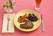 Place Setting with Grilled Pork Chop Served with Sweet Potato Fries and Red Cabbage
