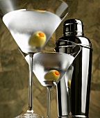 Zwei Gläser Martini mit Olive und Cocktailshaker