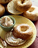 Sesame Seed Bagel Sliced in Half with Vegetable Cream Cheese; Bowl of Cream Cheese and Bagels