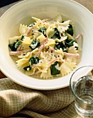 Farfalle with Spinach and Ham in a Cream Sauce in a White Bowl