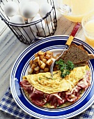 Ham Omelet with Home Fries and Toast; Eggs in a Wire Basket; Orange Juice