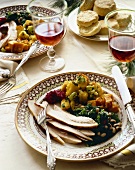 Holiday Dinner Plate with Turkey and Sides on Dinner Table with Wine and Biscuits
