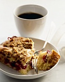 Piece of Cranberry Coffee Cake on a Plate with a Fork; Cup of Coffee