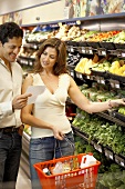 Mann und Frau mit Einkaufsliste im Supermarkt