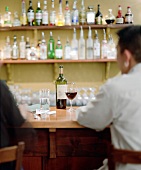 People drinking red wine at a bar counter