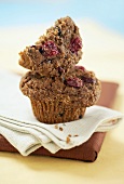 Half a cranberry bran muffin on a whole muffin