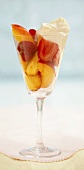 Fruit salad with cream in a stemmed glass