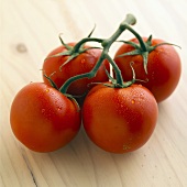 Four vine tomatoes with drops of water