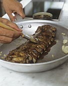 Brushing spare ribs with marinade