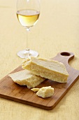 Parmesan Cheese on a Cutting Board with a Glass of White Wine