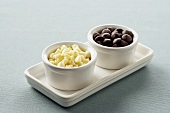 Two Small White Bowls on a Tray, One with White Chocolate Chips and One With Milk Chocolate Chips
