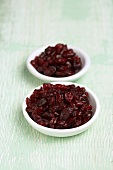 Two Small White Bowls of Dried Cranberries