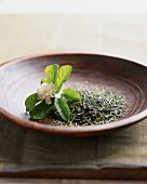 Close Up of a Bowl of Loose Oolong Tea Leaves with Jasmine Flower