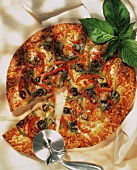 Gemüsepizza mit Paprikastreifen und Oliven, angeschnitten