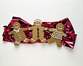 Three Gingerbread Men Resting on Foil Paper