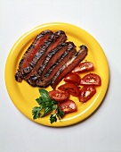Aufgeschnittenes Stück Steak mit Tomaten