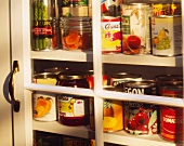 Assorted Canned Goods in a Glass Cupboard