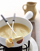 Fonduta (Cheese fondue with bread cube & piece of apple, Italy)