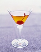 Ein Glas Manhattan mit einer Cocktailkirsche