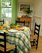 Country house table set in summery style with salad, corn