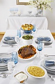 Gedeckter Tisch mit verschiedenen Gerichten für Hanukkah