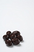 Small Pile of Chocolate Covered Raisins on White Background