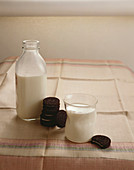 A Glass and Bottle of Milk with Oreo Cookies