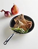Pork Chops in a Skillet with Sage and Rosemary, a Pear and Onion on the Side