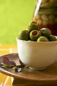 Gefüllte grüne Oliven in weisser Schale