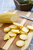 Partially Sliced Organic Yellow Squash on a Cutting Board