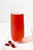 Glas Cranberrysaft und getrocknete Cranberries