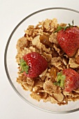 Bowl of Flake Cereal with Almonds and Dried Fruit Topped with Strawberries