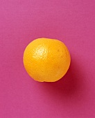 A Single Orange on a Purple Background