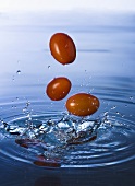 Tomatoes falling into water