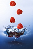 Raspberries falling into water