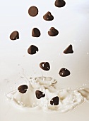 Chocolate chips falling into milk