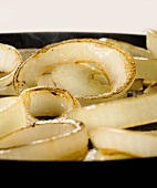 Onion rings being fried in a pan (close up)