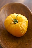 Freshly Washed Organic Yellow Heirloom Tomato on Wooden Dish