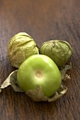 Drei Bio-Tomatillos auf Holzuntergrund