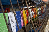 Colored Bandanas Hanging on a Clothes Line By an Iron Fence